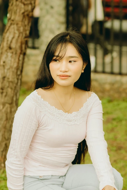 an asian woman wearing a white shirt posing for the camera