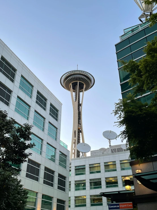 tall tower with the top extended in front of two smaller buildings