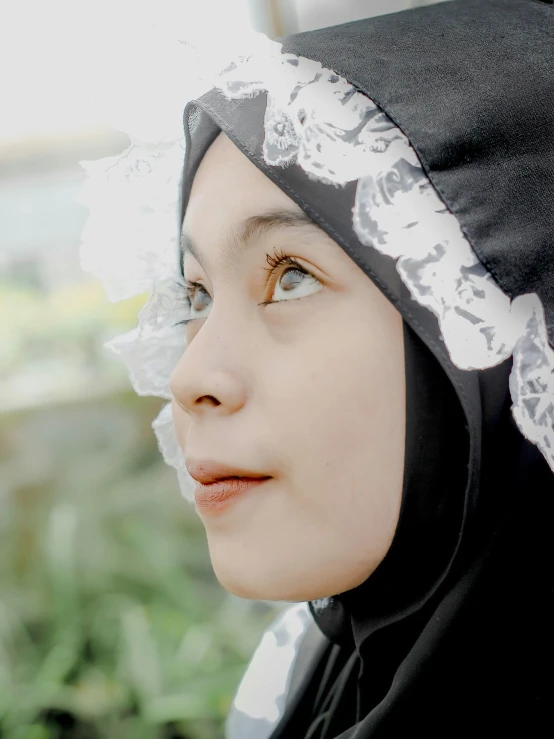 a young woman with a white frilled head covering