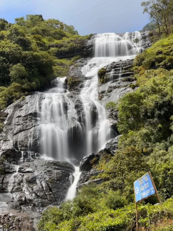 a small waterfall with green grass next to it