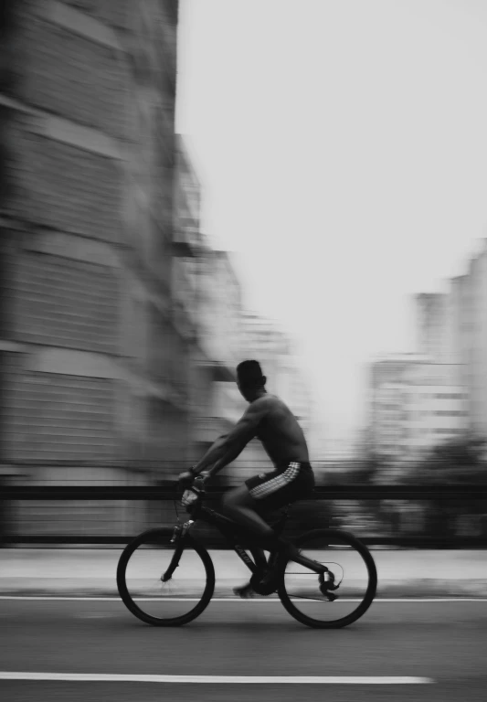 an image of a man riding his bike on the street