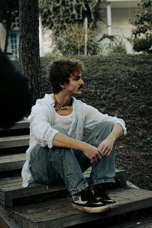 a person sitting on some steps in front of some trees