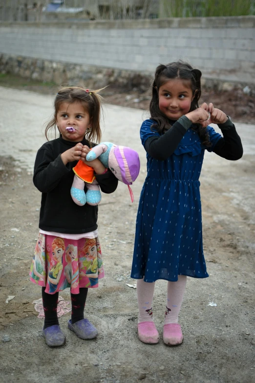 a pair of small children holding stuffed animals