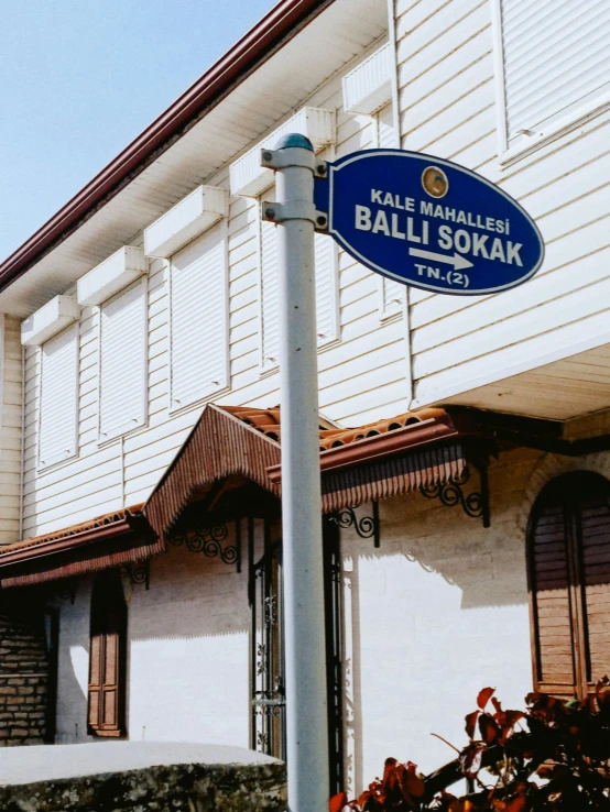 a tall building sitting next to a blue and white street sign