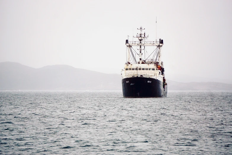 the large cargo ship is floating through the open water