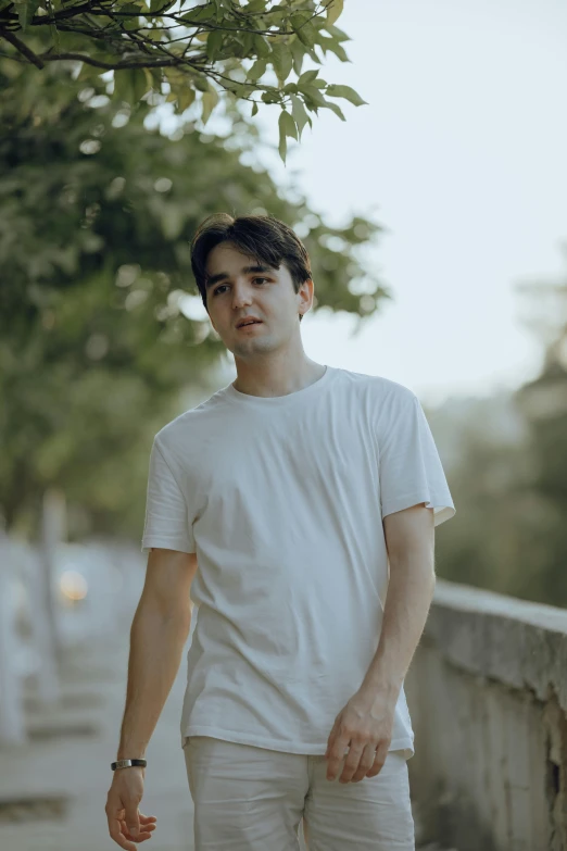 a man in white shirt walking on the side walk