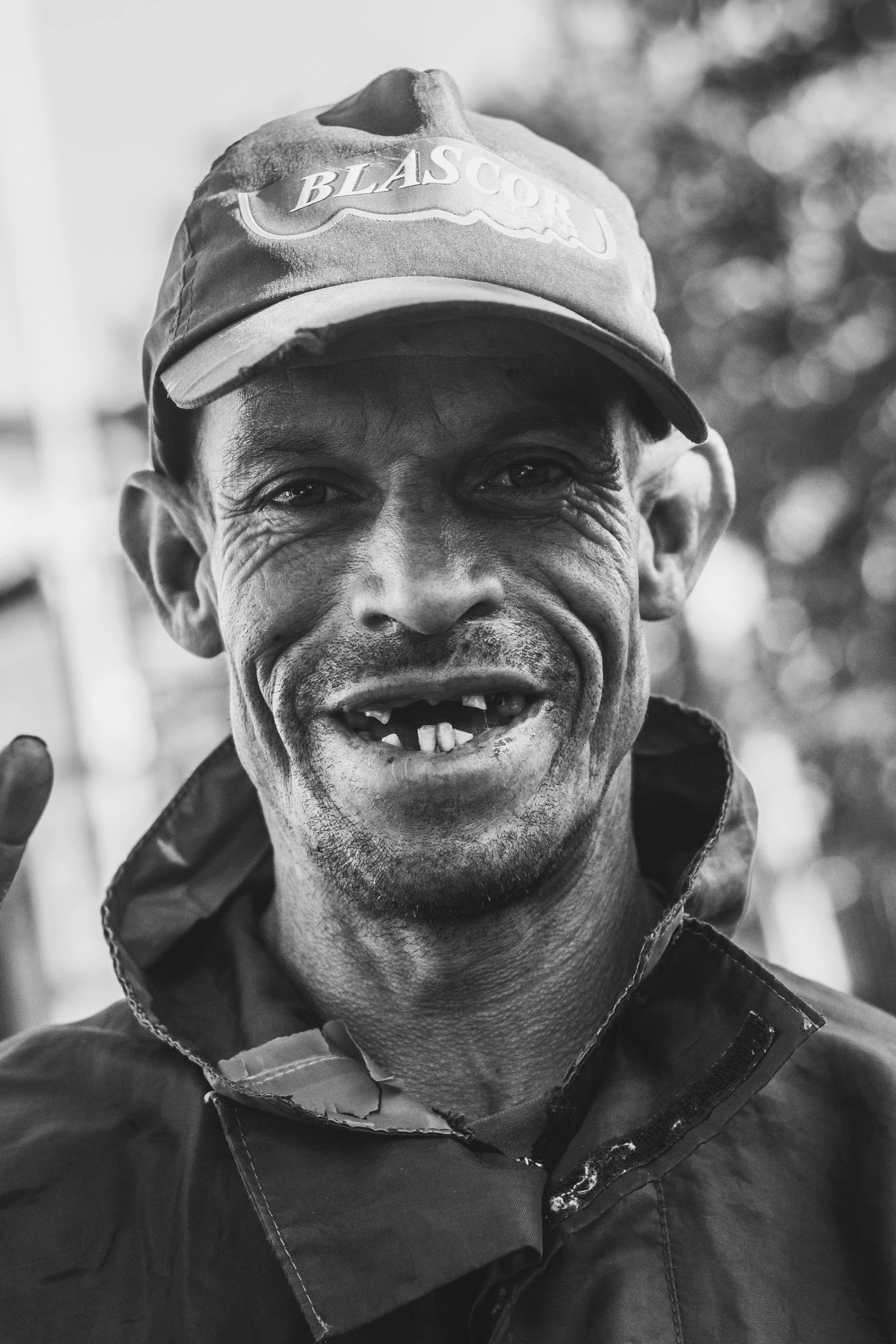 a man in a cap smiles and waves