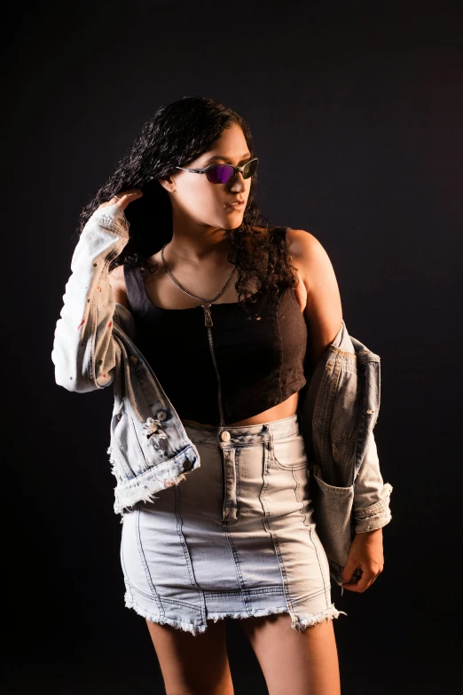 a beautiful young woman standing against a black background