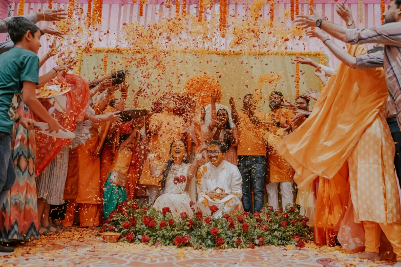 a group of people throw flower petals at each other