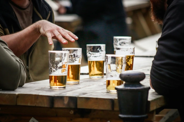 men sitting at table with lots of drinks