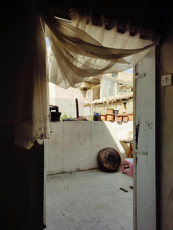 an open door to a porch with curtains hanging