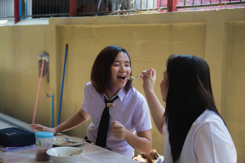 two women are eating and drinking together