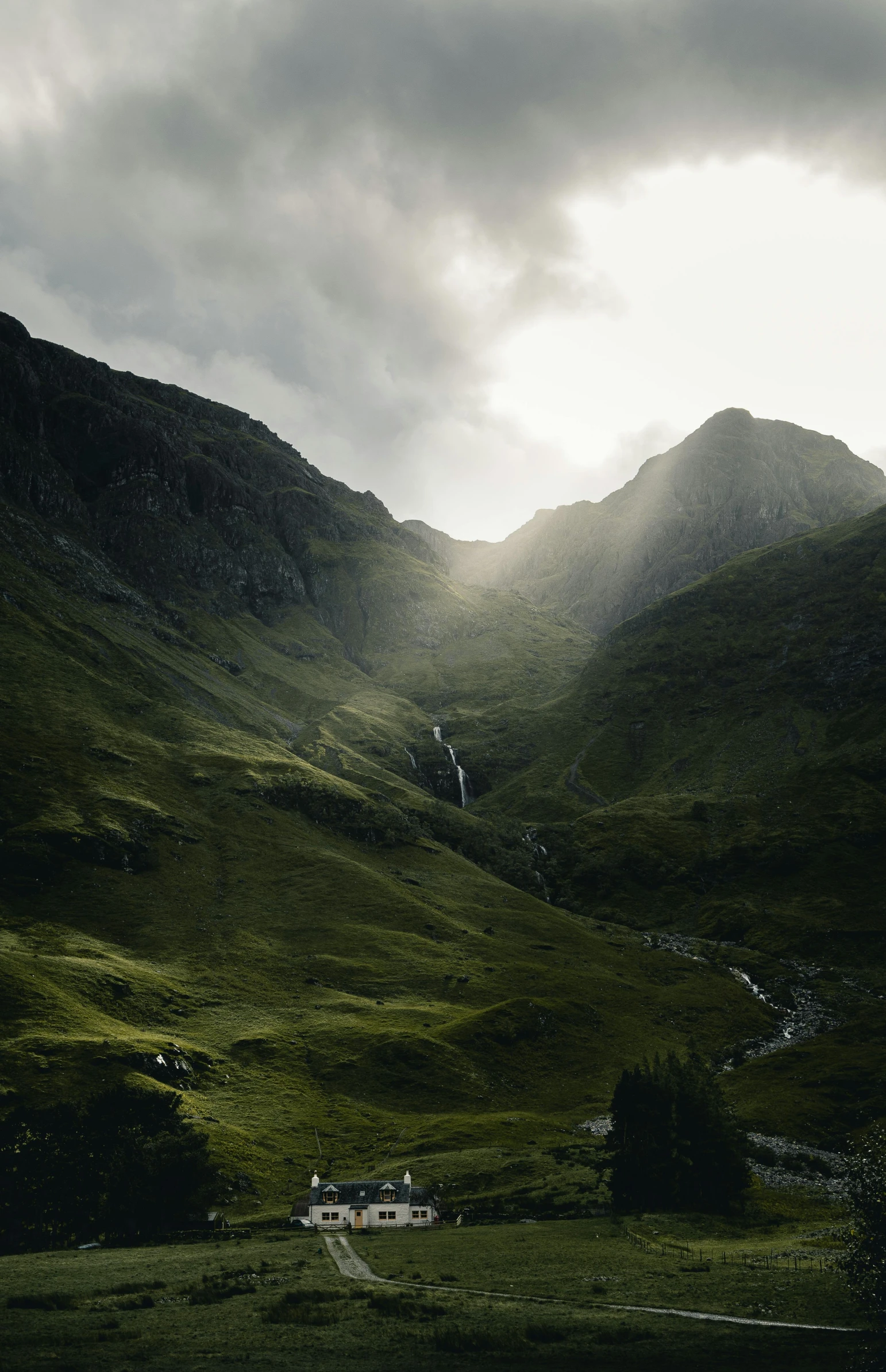 a cloudy sky hovers above mountains in the distance