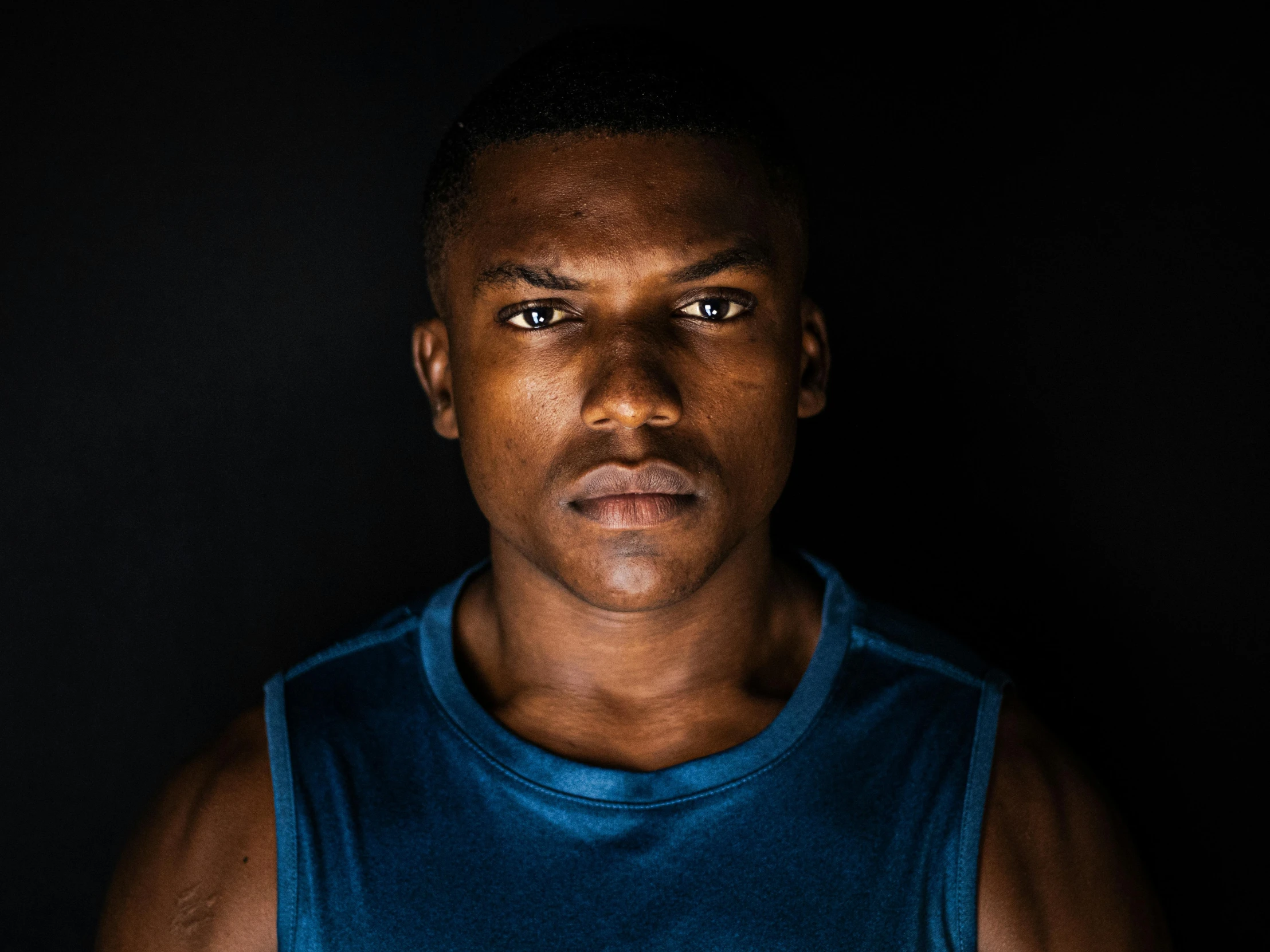 a man looks to his left while wearing a blue shirt