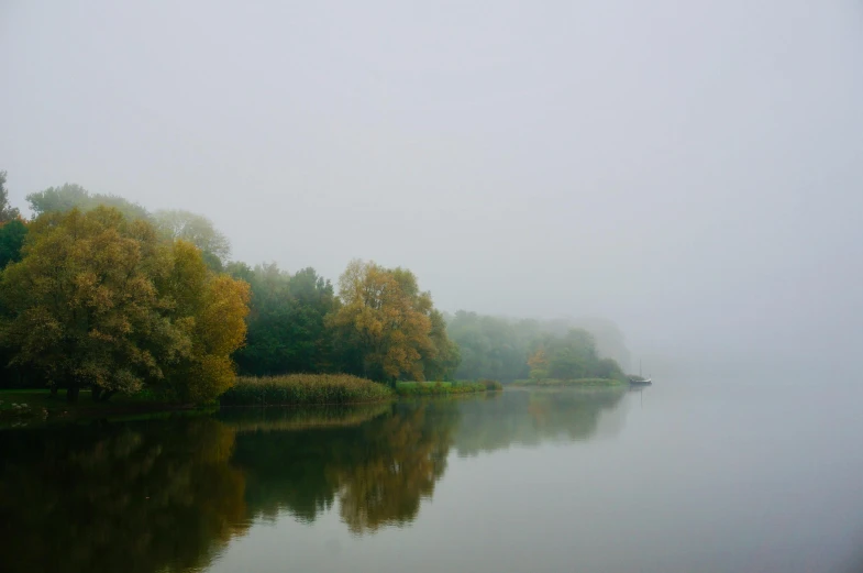 the water is calm on a foggy day