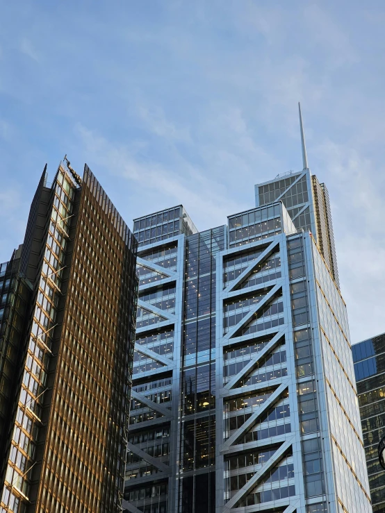 two office buildings, one with a sky scr on top, one without a light blue sky