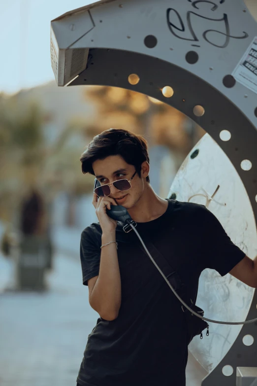 young man talking on a cellphone near the clock