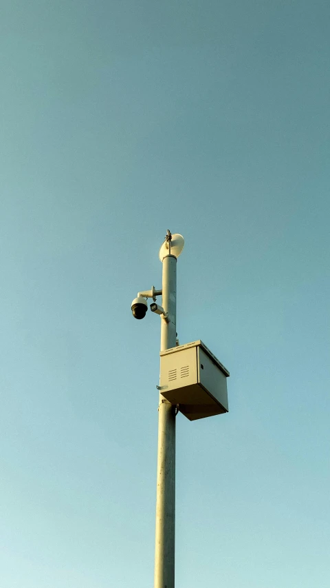 an industrial street light with a security camera attached to the pole