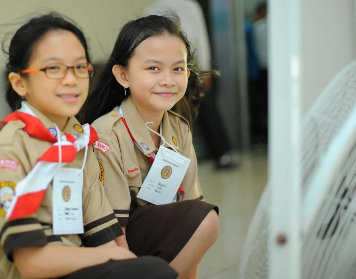 two girls with scout medals in uniform smiling