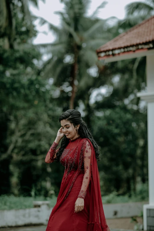 a beautiful young woman wearing a red dress walking in the street