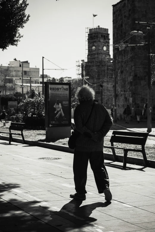 a black and white po of an old man walking in the city