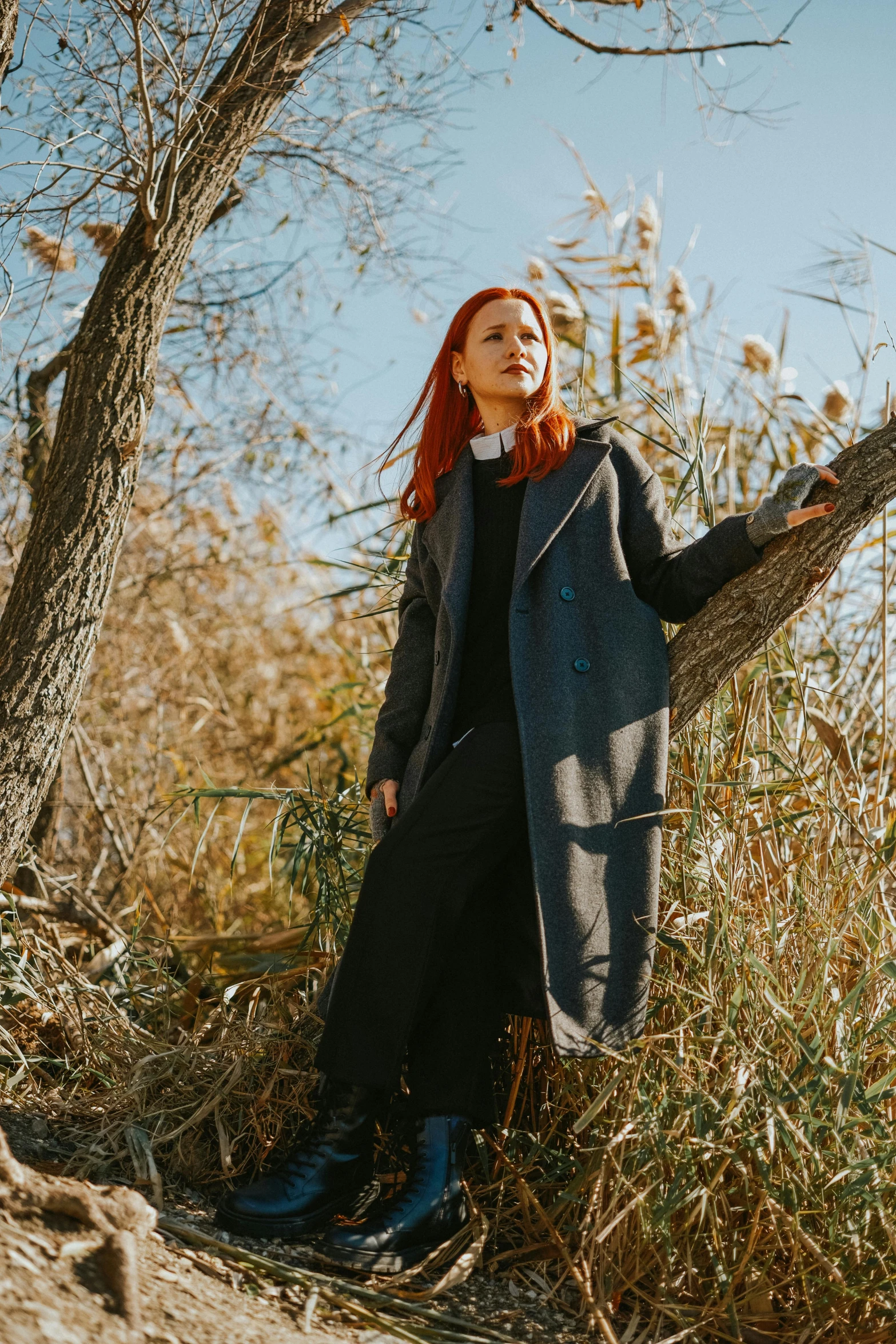 a woman is standing under a tree posing