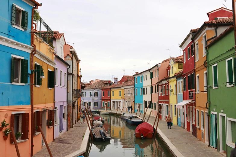 an alley of buildings with colorful facades and boats