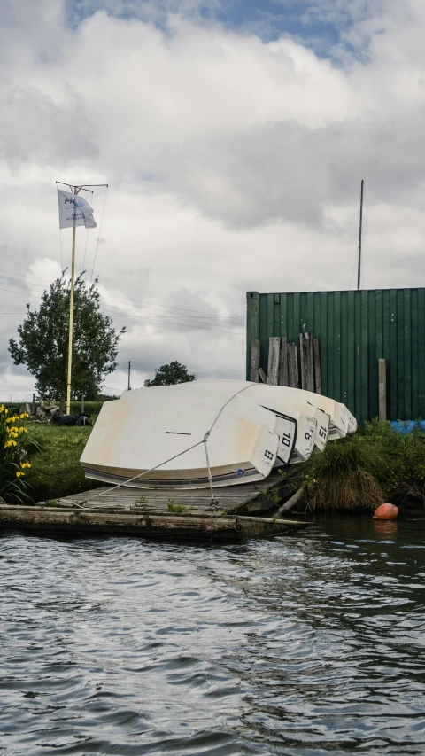 an overturned sailboat partially submerged in the water