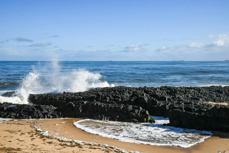 there is a wave coming in on the rocks