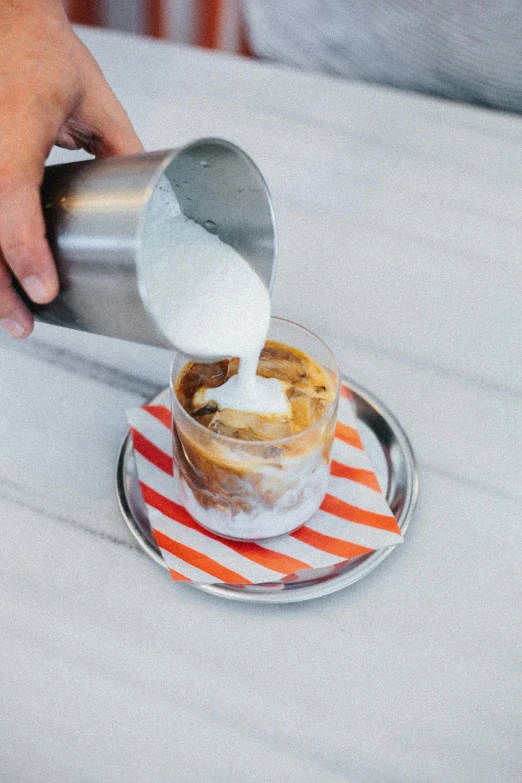 someone holding an object up while it's being poured onto a plate