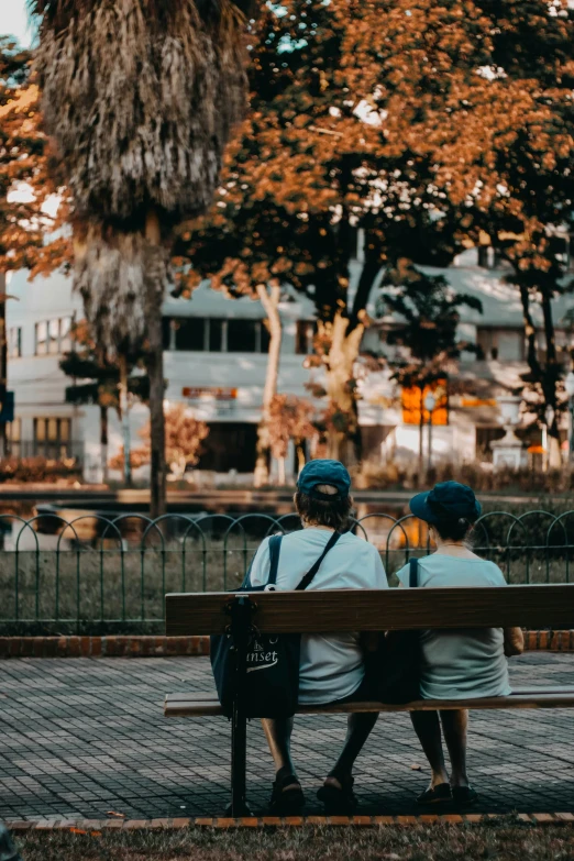 an elderly couple sitting on a bench looking in opposite directions