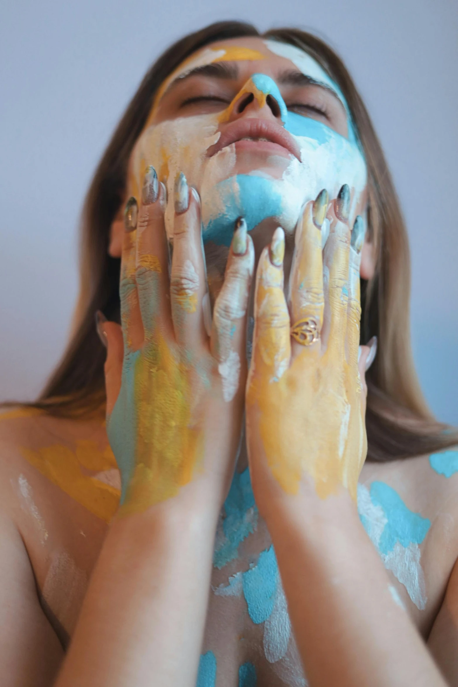 a woman with painted hands and a face covering