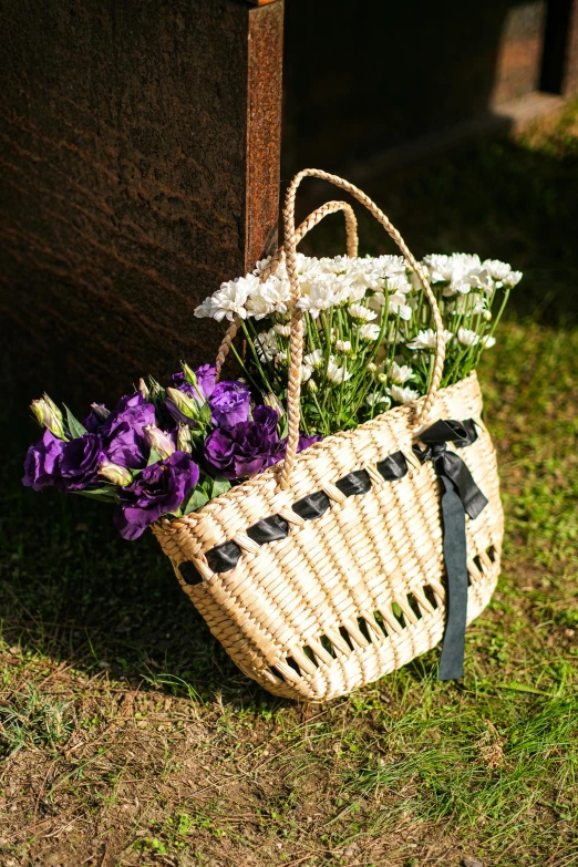 a wicker basket and flowers resting on the ground