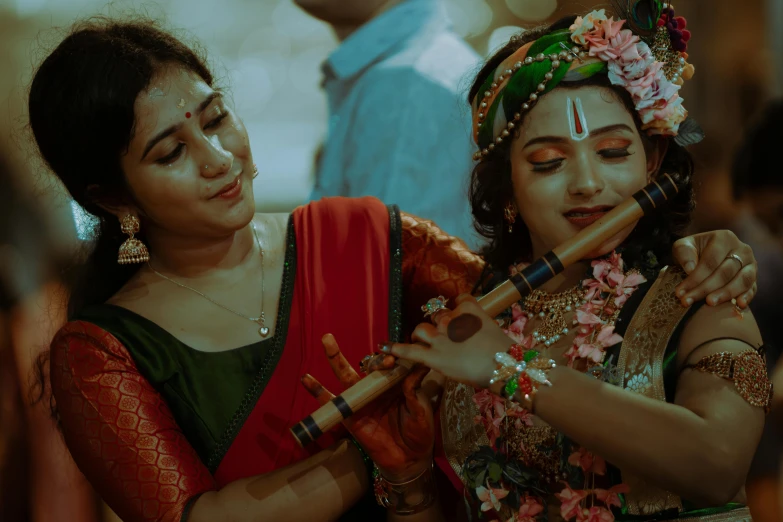 a woman in traditional indian garb plays a flute