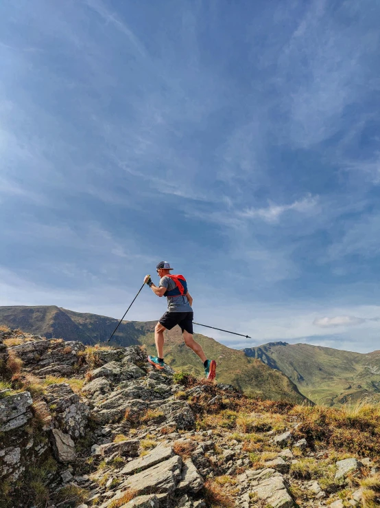 a person is climbing up some rocks with ski poles