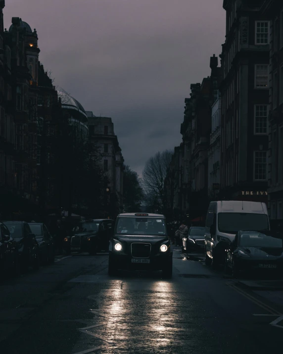 there is a car driving down the street in the rain