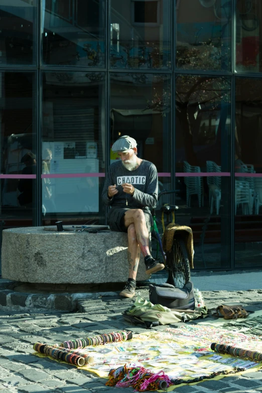 a man sitting on a stone bench in front of a window