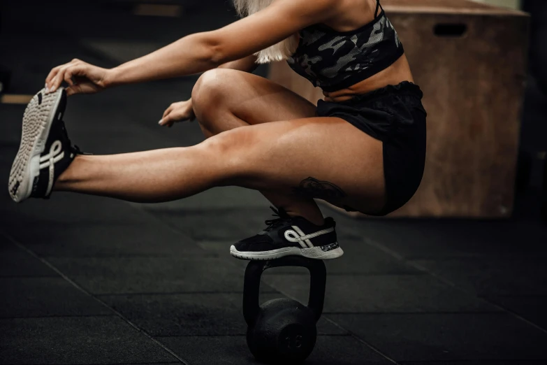 woman doing tricks on a pull - ups tube in the middle of the street