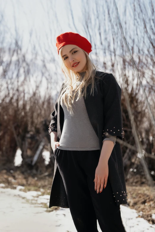 a  wearing a black and grey top and a red hat