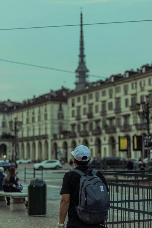 a person is walking on a wet road by the side of a building