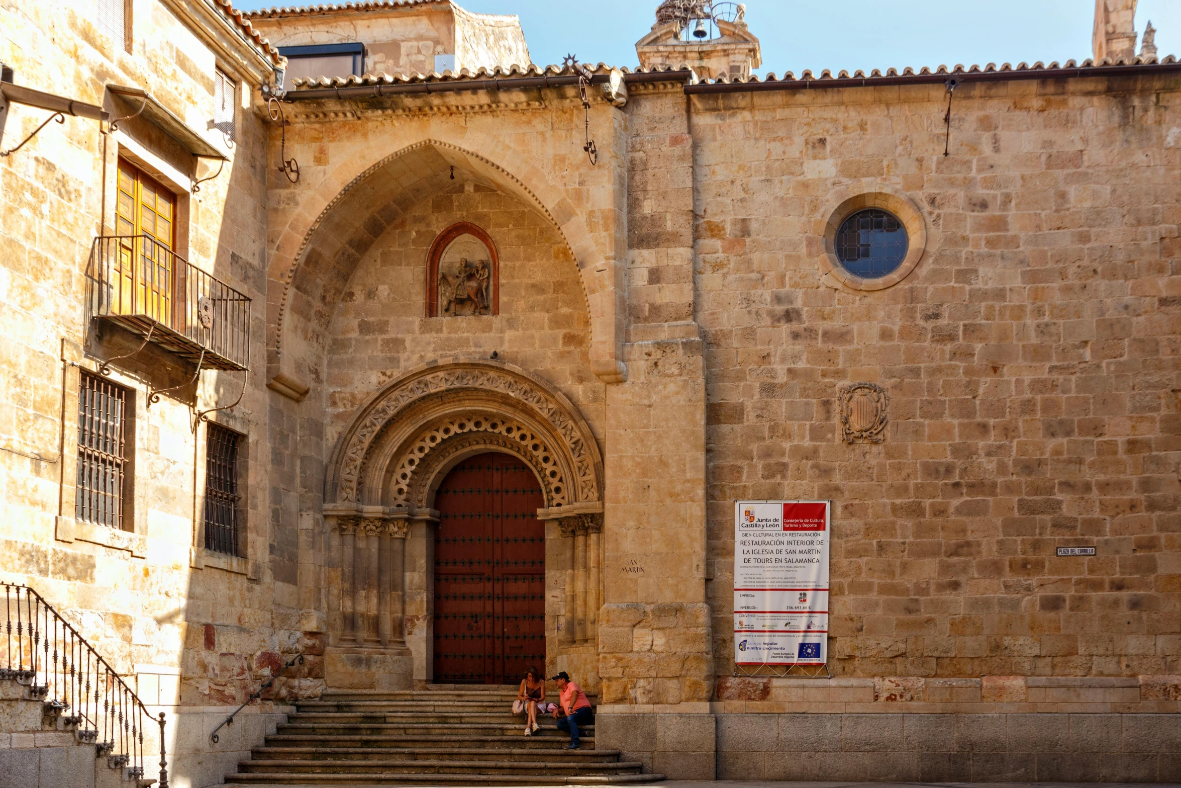 two people sitting on steps in front of a building