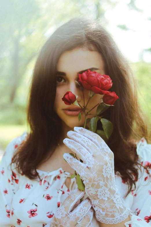 woman holding red rose with white gloves on