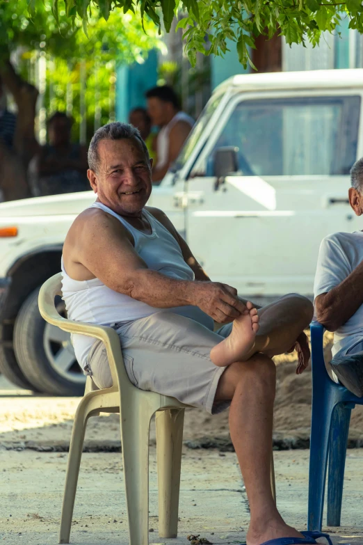 two older men sitting on lawn chairs near each other