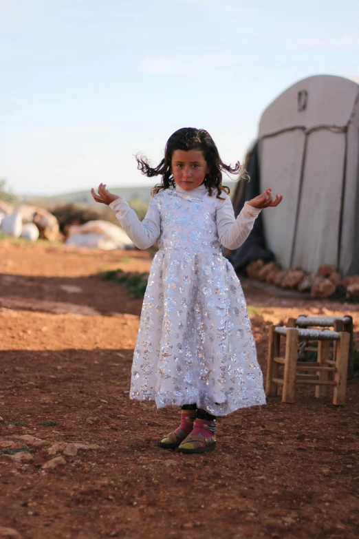 a girl in a white dress holding a white kite in her hands