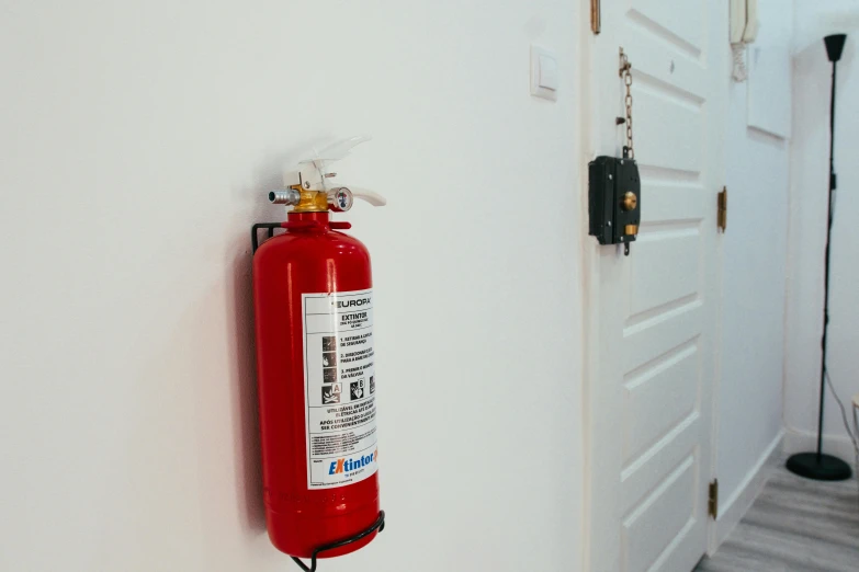 a red fire extinguisher hangs up on a wall