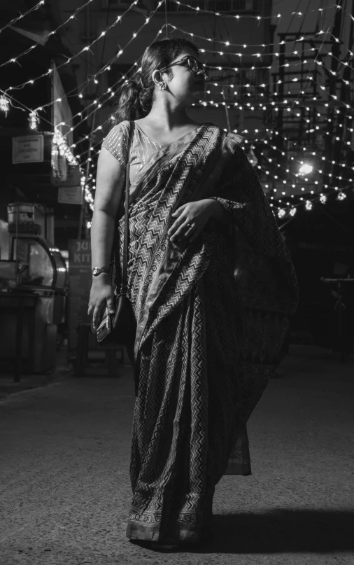 a black and white image of a woman in saree