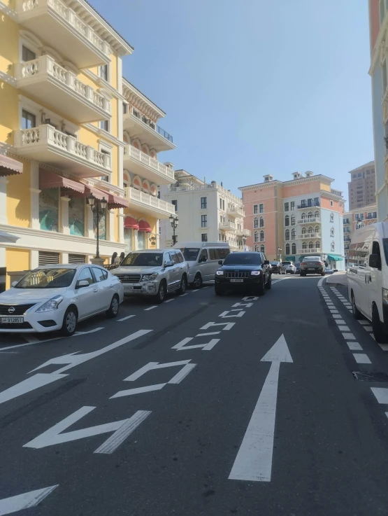 a street lined with parked cars next to yellow apartment buildings