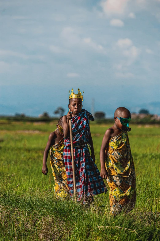 two woman in traditional clothing walk in an open field