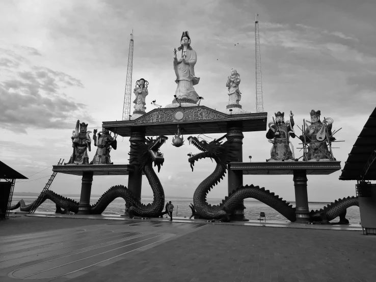 a dragon statue on top of a table next to the ocean