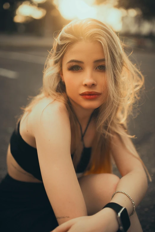 a woman with blond hair sits on the ground